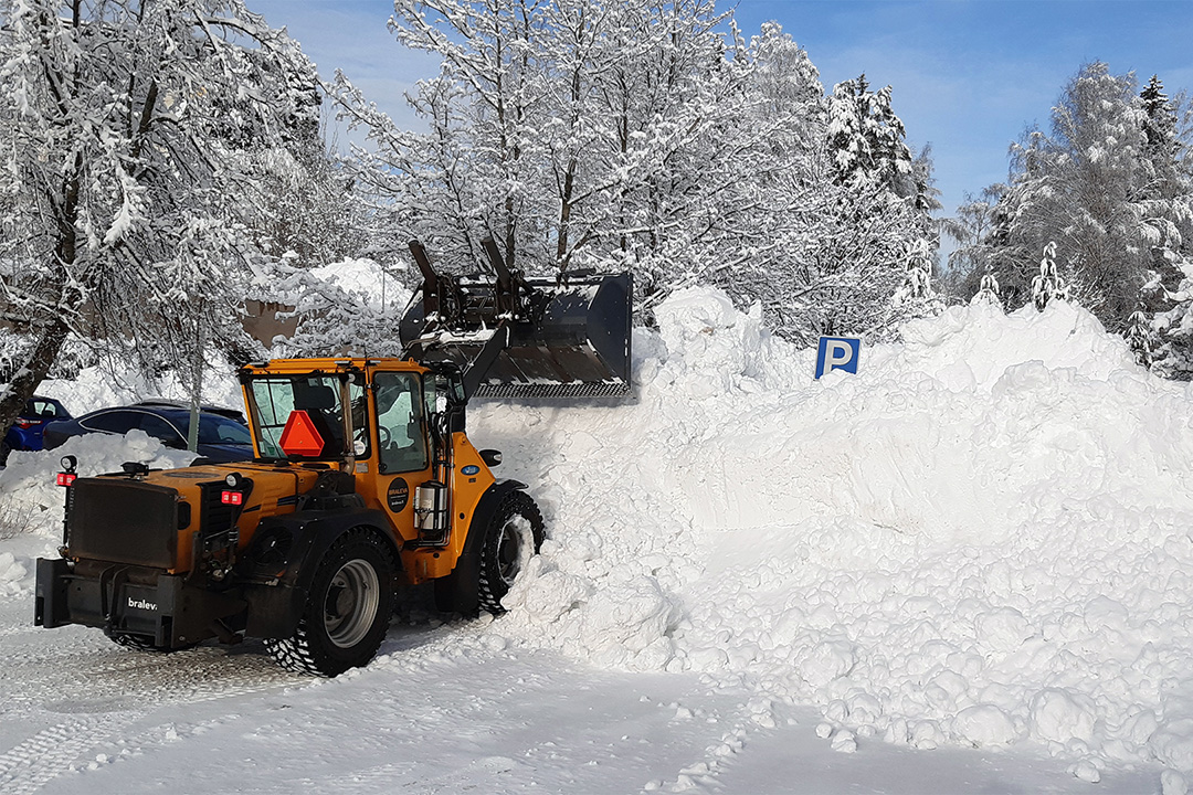 Keltainen kuormaaja ajamassa lunta, iso lumikasa